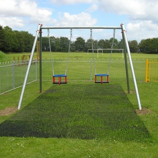 rubber grass mats under children's swings with grass beginning to grow through