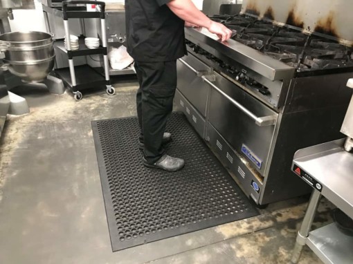 man standing on top of an anti slip mat before a stove