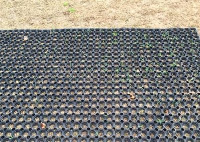 rubber mat laid on a very brown patch of worn grass