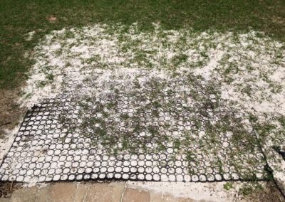 rubber mat on some sand with green grass beginning to come through