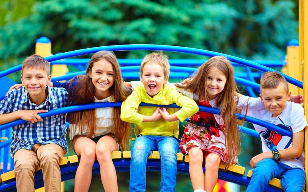 five kids sitting on daycare playground equipment