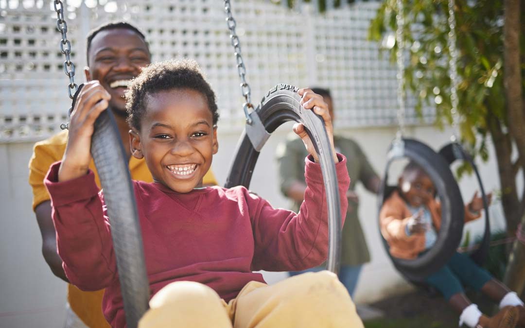 family playing in backyard on swings