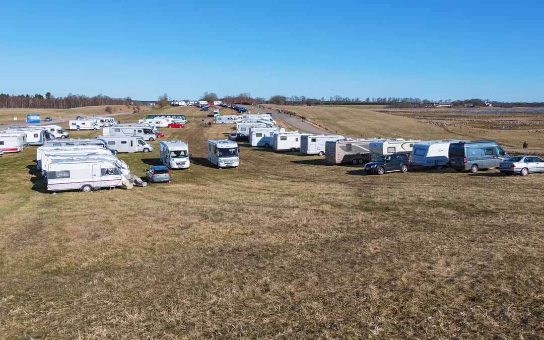 several RV's parked in an open field