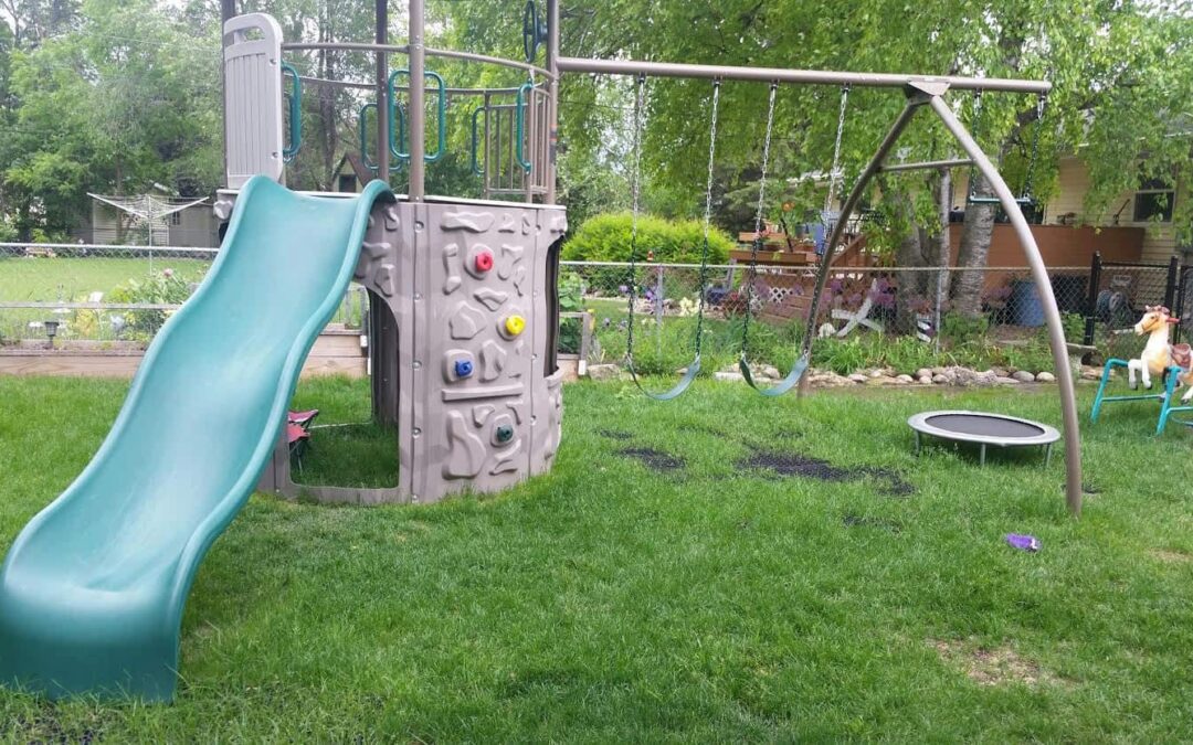 an image of a backyard playground using grass mats as the playground surface